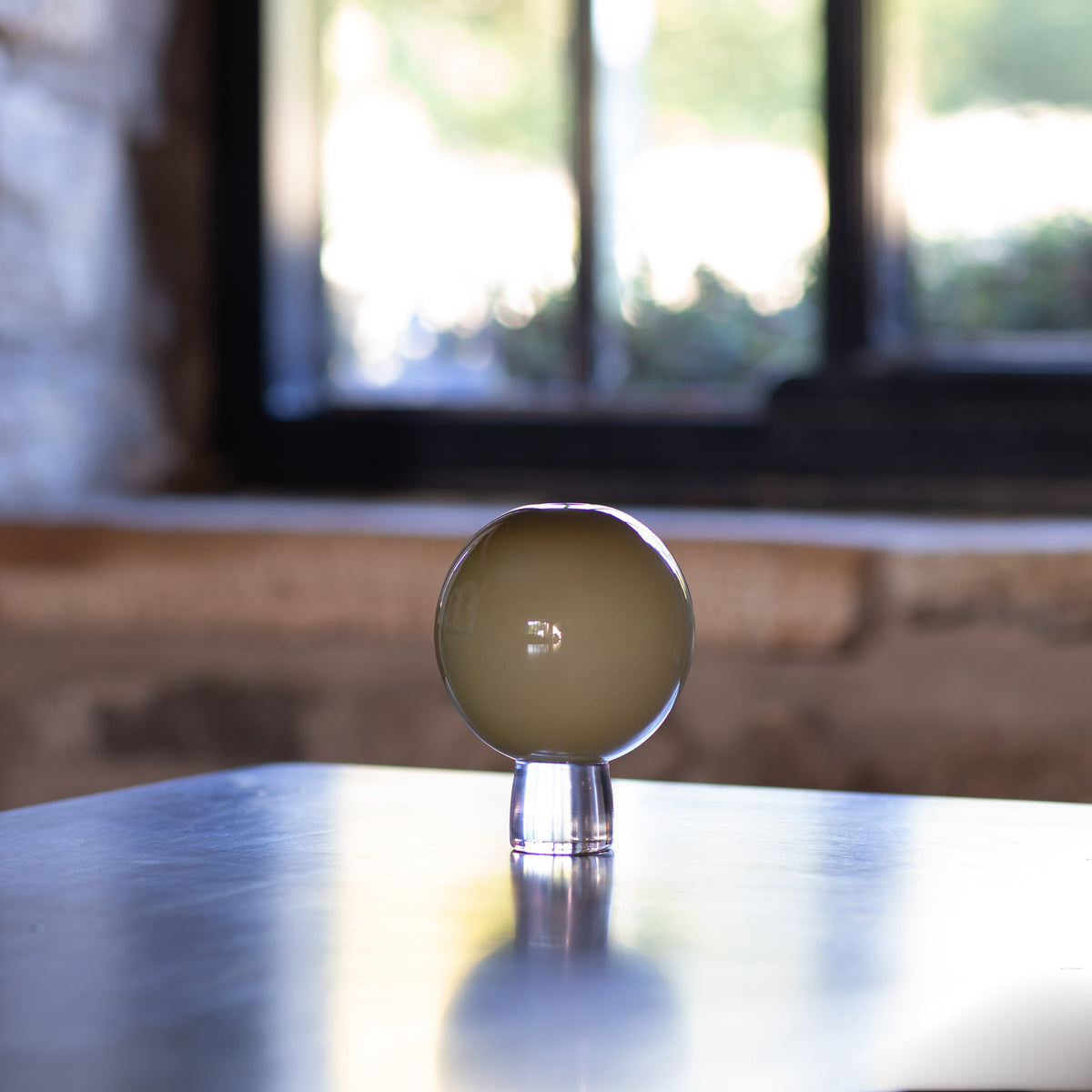 an opaque olive green hand made round glass vase 
